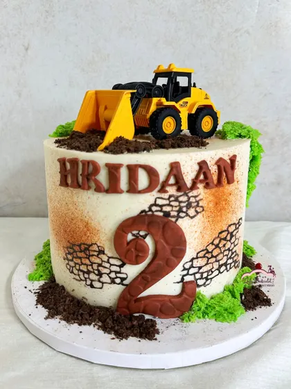 I dig this excavator cake! Designed for a construction-loving two-year-old, this cake has edible dirt, a stone-textured number 2, and a toy JCB on top.