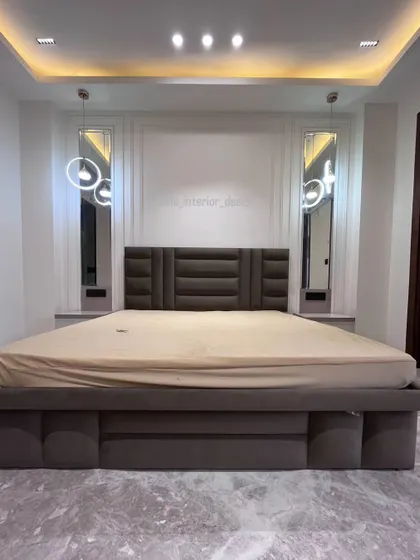 This wide shot shows the entire bed and back wall, giving a sense of the room's spacious and uncluttered feel.