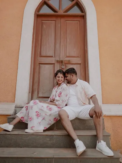 A sweet and relaxed moment, sitting together on the steps of a colorful building in Alibag.