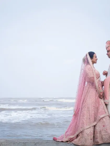 Shivani and Aniket in their stunning wedding attire, sharing a look by the sea. A pre-wedding shoot can also be a beautiful prelude in your final outfits.