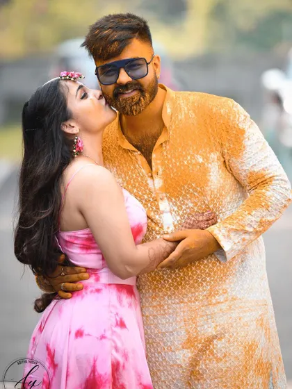 A heartwarming moment between a brother and sister during a haldi ceremony. The sister's affectionate kiss shows the beautiful family bonds that are such an important part of any wedding.