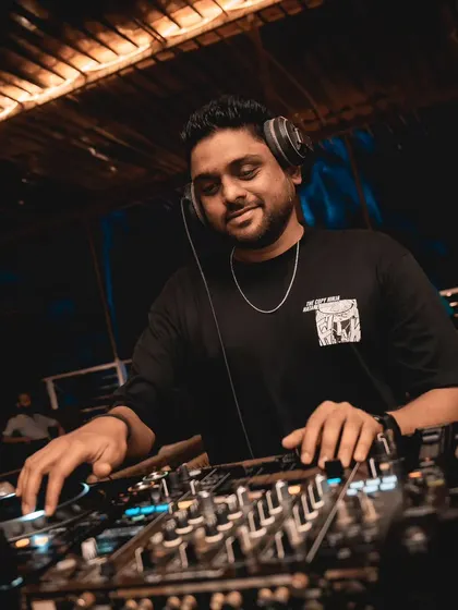 A smile on my face while I spin tracks at a Goa party. The beachside setting is perfect for my blend of Reggaeton, House, and commercial hits.