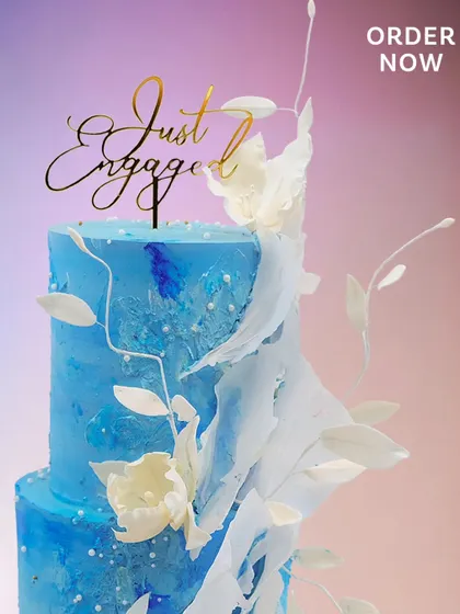 A close-up view of the handcrafted sugar flowers and delicate leaves on the "Velvet Skies" engagement cake. Each element is made to look as light as air.