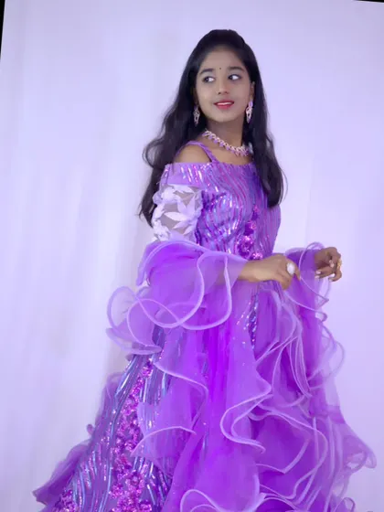 A stylish pose in a modern purple lehenga with off-shoulder sleeves and sequin details.