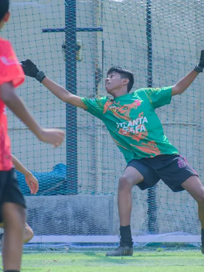 A goalkeeper making a full-stretch save during a match. Our training prepares them for crucial, game-defining moments like this.