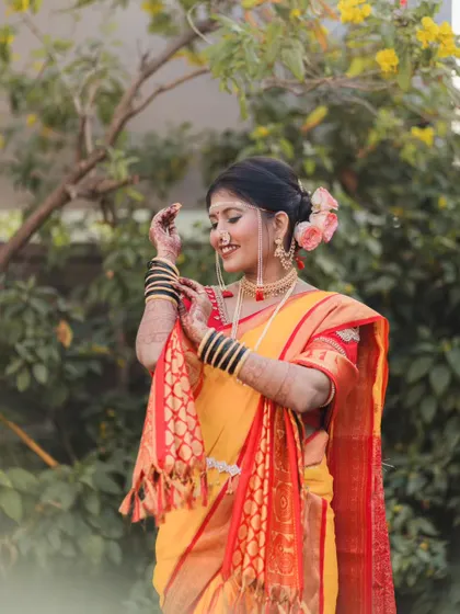 A candid moment of the bride adjusting her shela (dupatta), smiling as she prepares for her wedding ceremony.