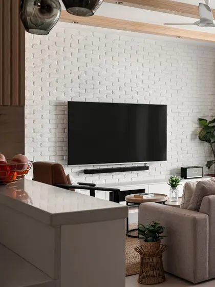 A view from the kitchen into the living area, showing how an open-plan layout can make a home feel connected. The white brick wall serves as a stylish backdrop for the entertainment zone.