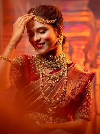 An artistic shot of a bride enjoying her moment, adorned in our full temple jewellery set. You can rent these pieces to make your own wedding photos just as memorable.