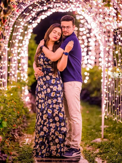 A tender embrace within the tunnel of lights. This full-length shot captures the couple's connection in a beautifully illuminated and romantic setting.