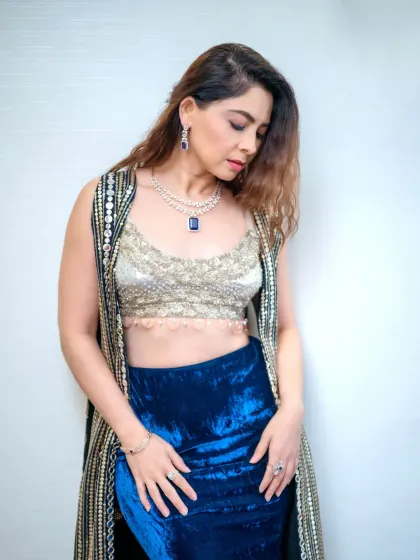 A full-body portrait showcasing a modern, glamorous look with a blue velvet skirt and an embellished top. This type of shot is perfect for fashion or celebrity portfolios.