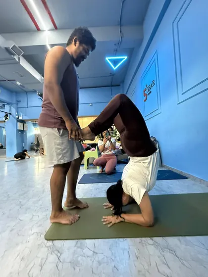 Assisting a student in a headstand variation in our Malad West advance class. This batch is for yoga teachers and dedicated practitioners.