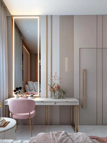 A dedicated dressing area featuring a sleek vanity table with integrated drawers and a full-length mirror with built-in LED lighting. The plush pink chair adds a touch of color and elegance to this functional corner.