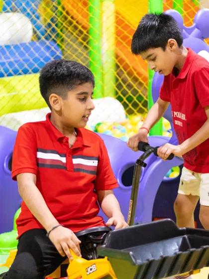Big brother helping his younger sibling with the ride-on tractor. Our play area is designed for kids of different ages to interact and play.