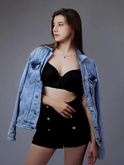 A classic mid-shot of a model in a denim jacket against a grey background. This is a fundamental portfolio image that is clean, professional, and versatile.