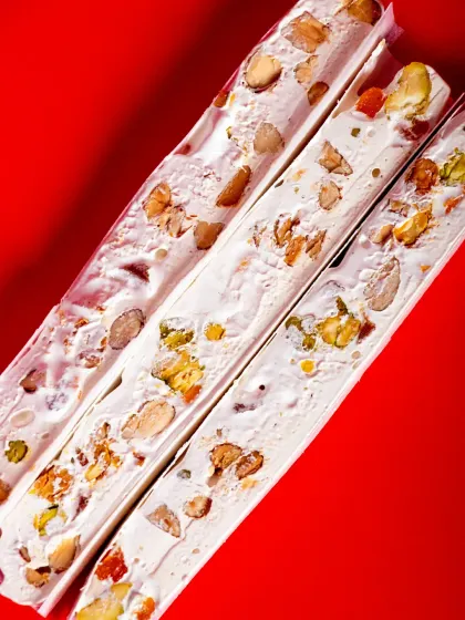 My handmade Nougat is a chewy Franco-Italian Christmas treat. It's made with whipped egg whites, honey, apricots, and nuts, and wrapped in edible rice paper.