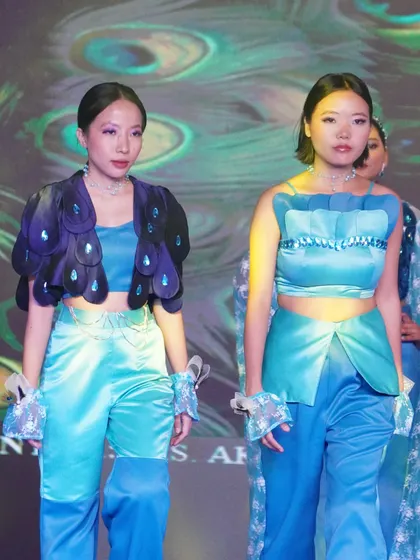 Two models present coordinated outfits in shades of blue, showcasing a cohesive design vision.