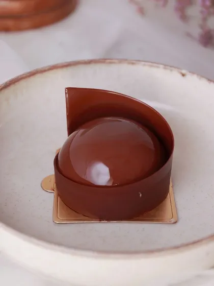 Our Triple Chocolate Mousse is an elegant dessert featuring layers of dark, milk, and white chocolate mousse for the ultimate indulgence.