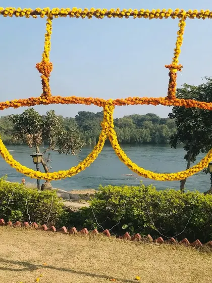 A quirky and fun photo prop for a Haldi ceremony, shaped like oversized sunglasses and made entirely of marigold flowers.