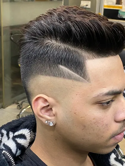 A close-up of a high skin fade with a precise side part and a sharp line design. This angle highlights the clean execution of the cut and the defined edges.