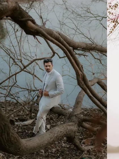 A stylish portrait of the groom-to-be posing amongst the dramatic, bare branches of a tree by the water's edge.