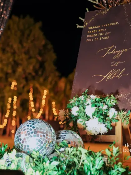 "Shaam Shaandar." A chic welcome sign for a sangeet, complete with disco balls and elegant calligraphy, setting the mood for a night under the stars.