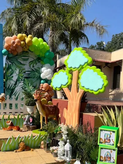 Another angle of the jungle-themed photo corner, with various animal figures and a balloon garland.