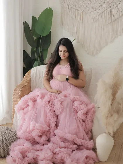 A quiet, contemplative pose in a pink ruffled gown. Our boho corner with its natural textures and plants provides a perfect, serene setting.