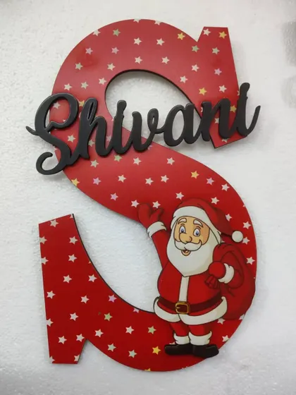 A Christmas-themed initial wall hanging, personalized with a name. This "S" for Shivani features a cute Santa design.