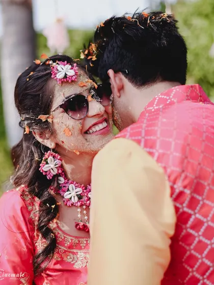 A sweet and playful moment during the Haldi ceremony, as the bride gets haldi applied by the groom.
