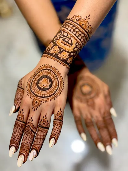 Divya's wedding mehendi, a mix of modern and traditional with a central lotus mandala and a detailed wristband featuring a wedding palanquin (doli).