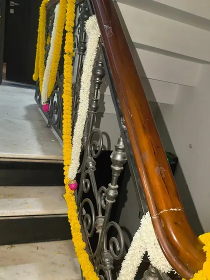 A classic staircase decoration for Diwali using alternating garlands of yellow marigold and white flowers.