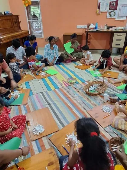 Children work diligently on their paper flower crafts. These activities are designed to be accessible and fun for a range of ages and skill levels.