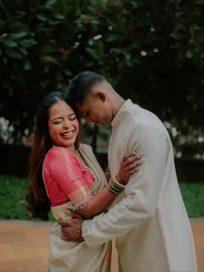 A candid shot filled with pure laughter and joy. This photo from an engagement session captures a genuine moment of happiness between the couple in their traditional outfits.