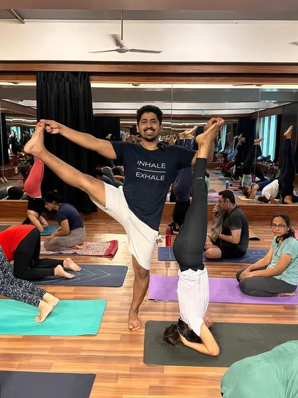 A fun moment with a student in a headstand during our community practice. We support each other's growth.