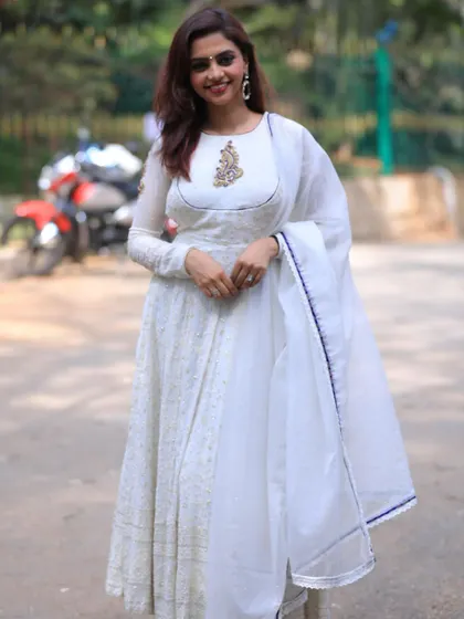 A vision in white. I designed this elegant white Anarkali with a delicate, hand-embroidered motif on the neckline. It's a timeless and graceful outfit, perfect for a special occasion.