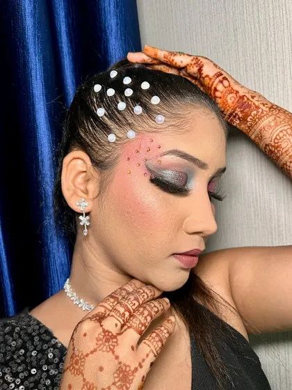 A close-up of a dramatic eye makeup look with silver and black eyeshadow, perfect for a cocktail party or reception. The pearl hair accessories add a touch of elegance.