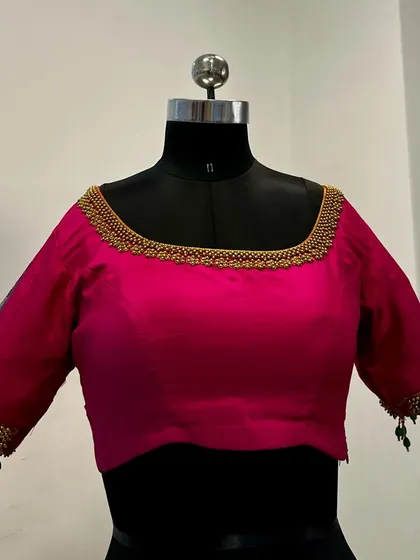 The front view of the pink hand-painted blouse, featuring a simple square neckline that lets the intricate artwork on the sleeves and back shine.