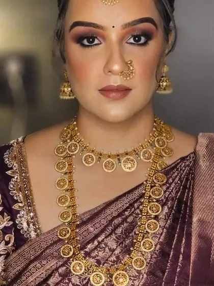 A model with a bold makeup look, perfectly complemented by a traditional gold coin necklace, or kasu haram.