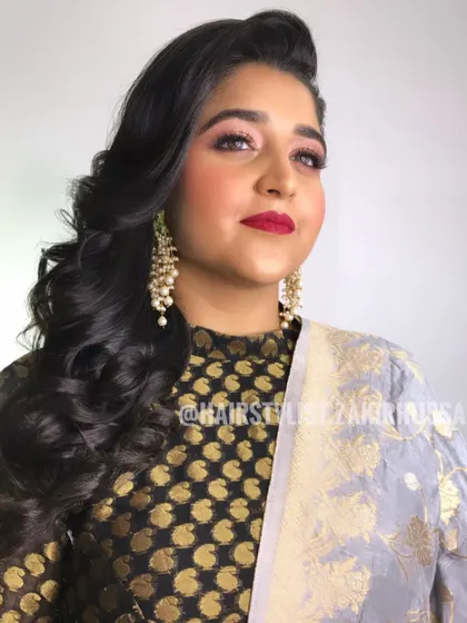 A glamorous look with side-swept waves and a small side braid for detail. This is a great style for a reception or sangeet.