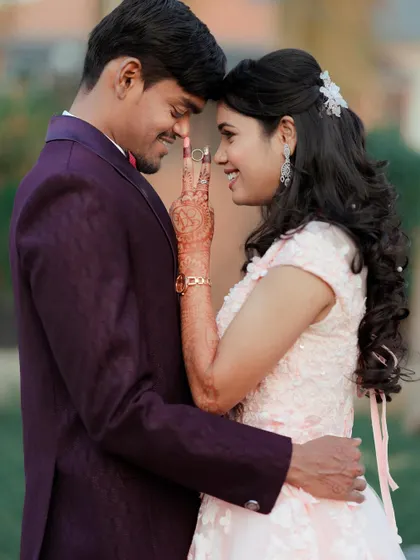 A close-up filled with love and joy. This shot highlights the delicate details on the bodice of the pink ball gown and the bride's beautiful henna.