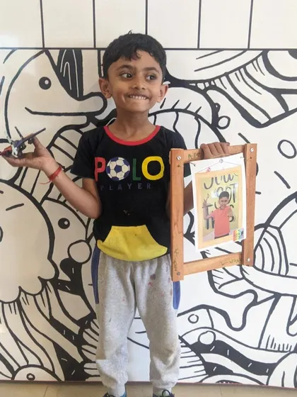 This young creator is thrilled with his two finished projects: a custom-painted model jet and a handmade wooden photo frame.