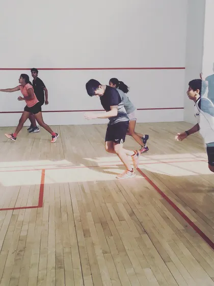A group of players engaged in a high-intensity running drill on the court. These sessions are designed to improve cardiovascular fitness and the ability to sustain effort throughout a tough match.