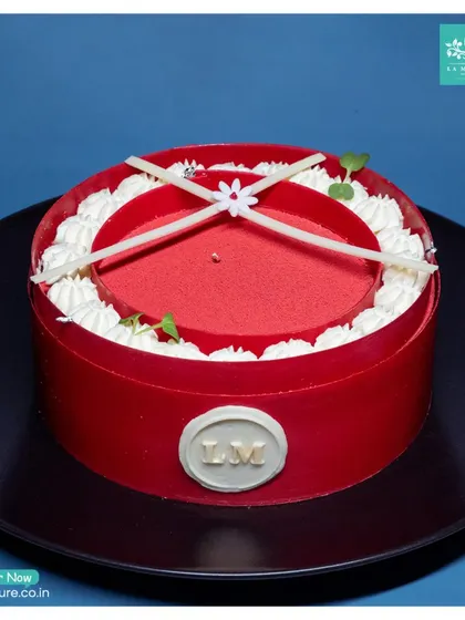 This striking Red Velvet entremet cake is designed to impress. Its bold red exterior, delicate white chocolate details, and our signature 'LM' seal make it a perfect centrepiece.
