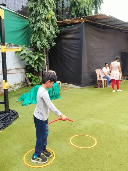 Aim for the target! Using a hula hoop for ring toss is a great way to practice hand-eye coordination. We turn it into a friendly competition to see who can score the most points.