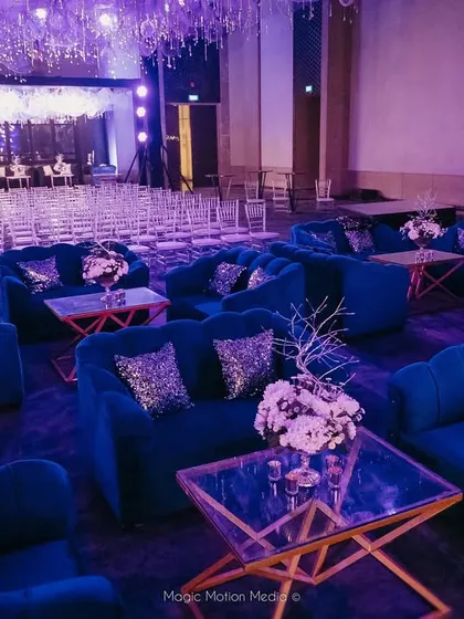 The Sangeet lounge area with royal blue sofas and sparkling silver cushions.
