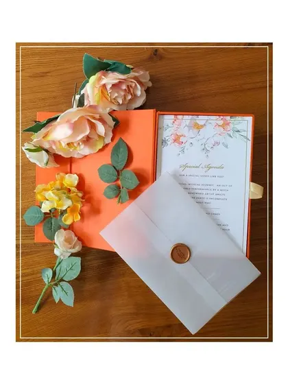 We design luxury boxed invitations for all of life's special occasions. This vibrant orange box, featuring delicate gold-foiled floral line art, was created for a naming ceremony and includes a vellum-wrapped insert with a wax seal.