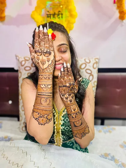 The happy bride showing off her beautiful back-hand mehendi.