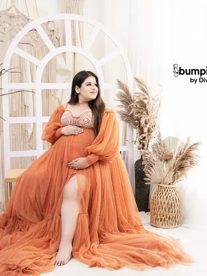 A confident and beautiful solo shot. The slit in the orange gown adds a touch of modern style to this otherwise classic boho maternity portrait.
