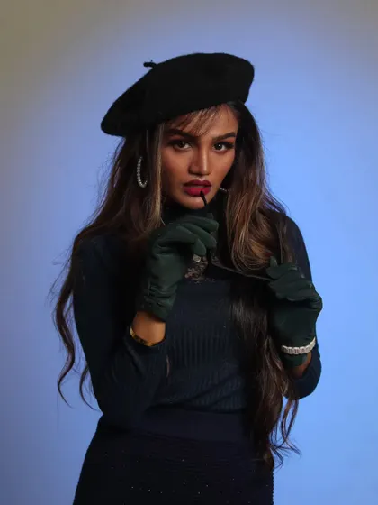 A high-fashion studio look with a beret and gloves against a colored gel background. This shows how we can get creative with lighting and style.