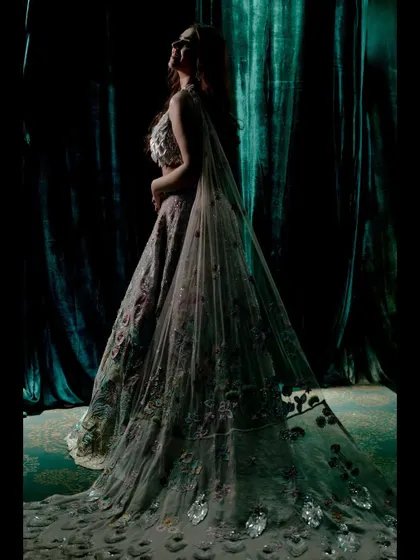 A dramatic portrait of Khushboo in her exquisite Rahul Mishra lehenga. The lighting and her pose highlight the incredible detail and artistry of her outfit.